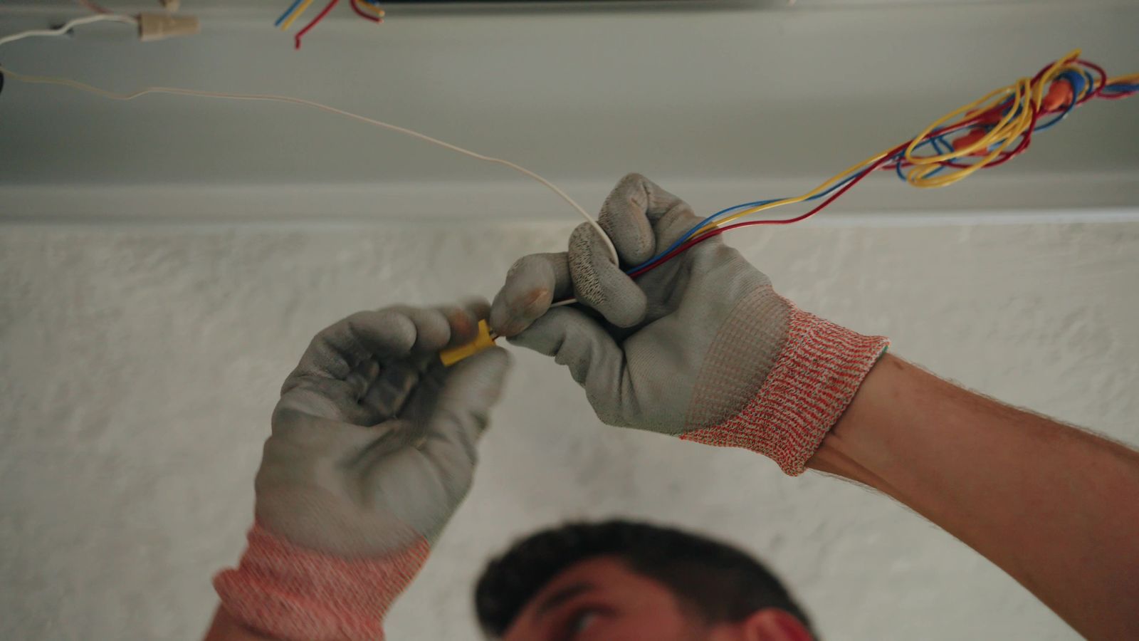 Gloved hands making up conductors on a United Electric Service job